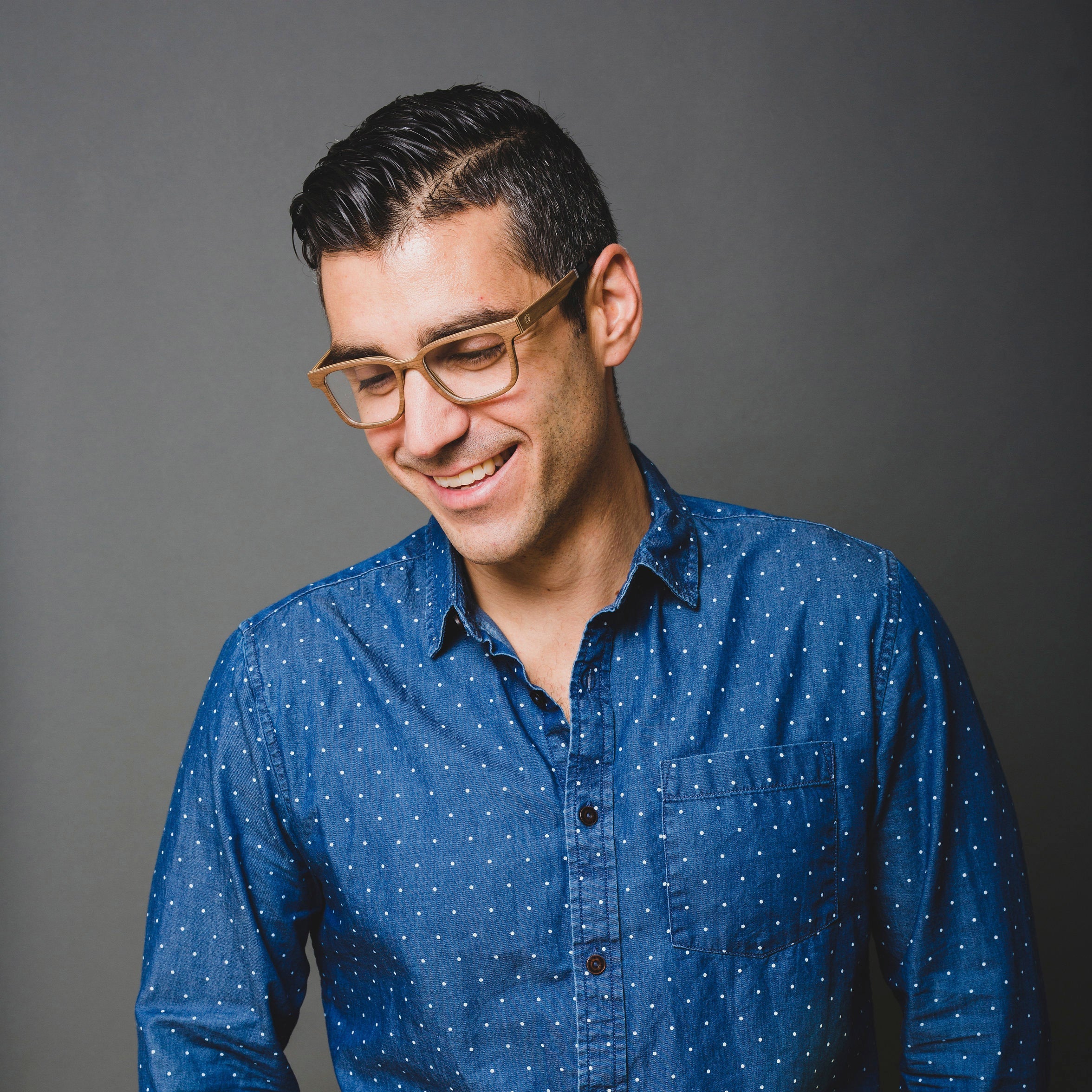 man smiling wearing brown wood glasses