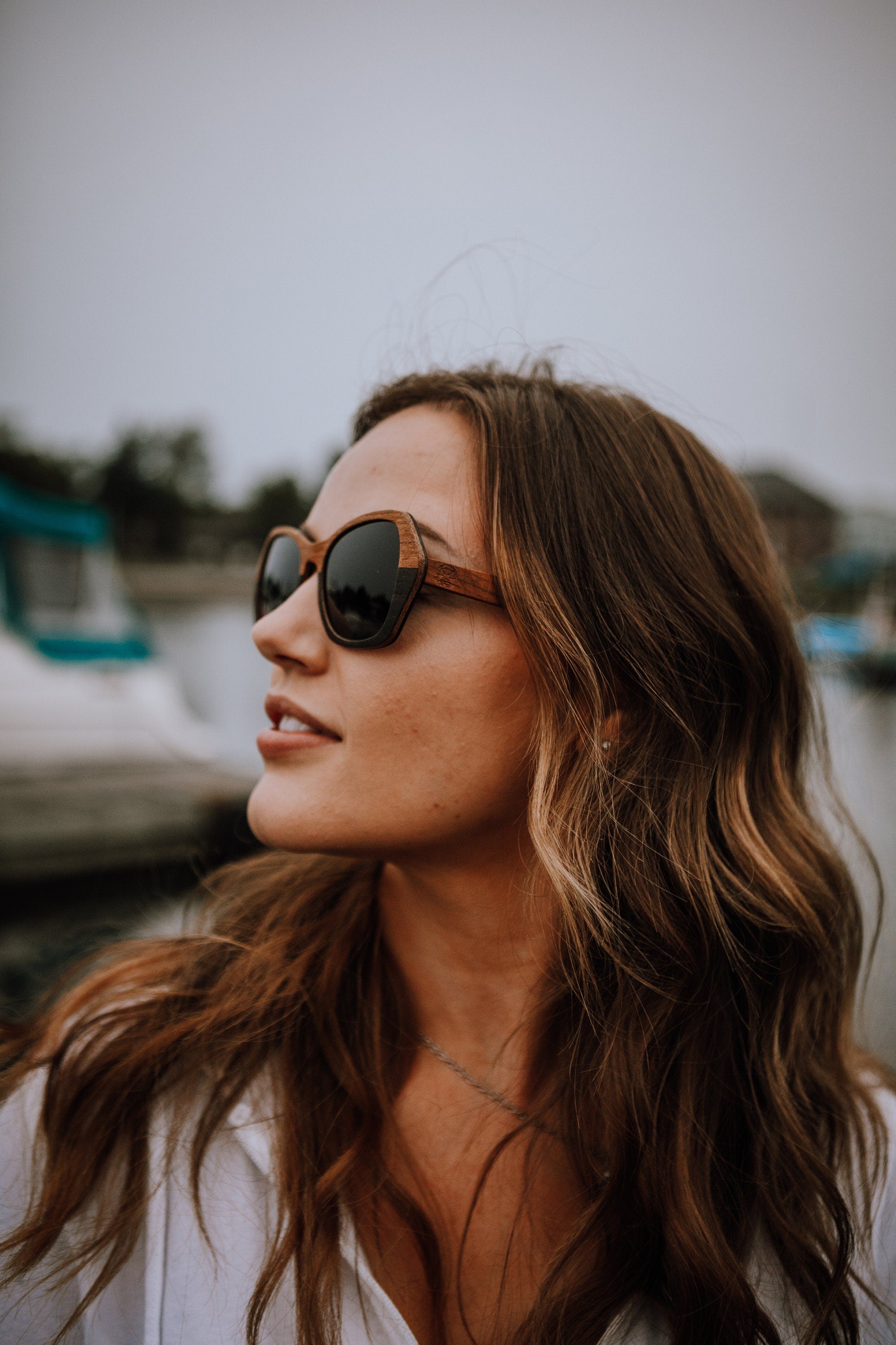 woman looking sideways wearing wood sunglasses
