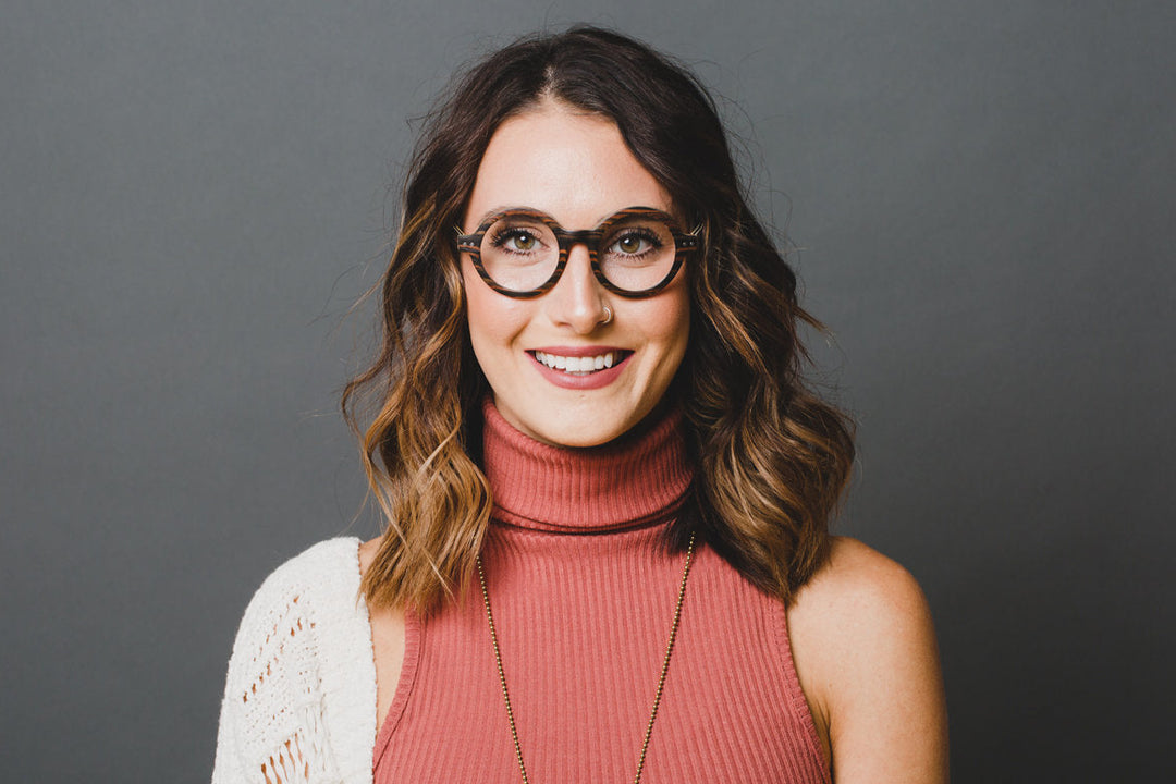 Woman wearing black sandalwood round vintage eyeglasses. 