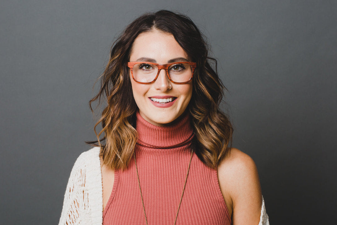 Woman wearing turtleneck and red wood glasses.