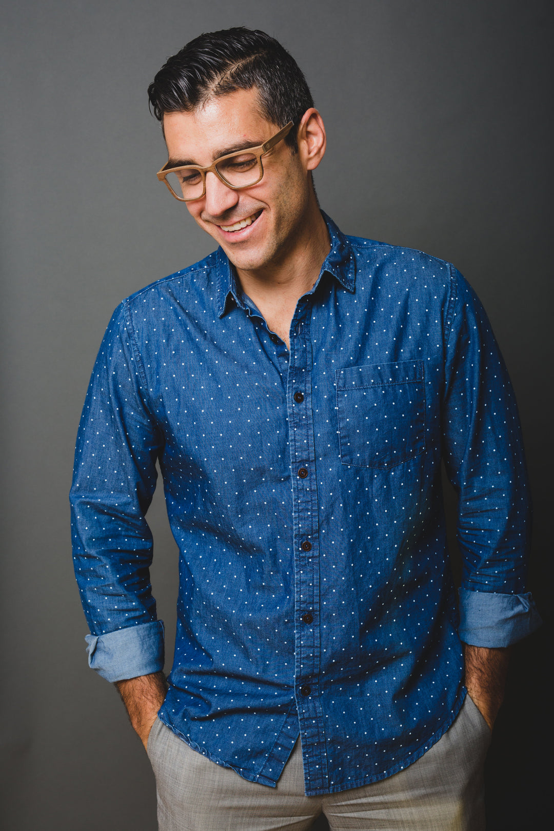 man standing wearing brown oak glasses.