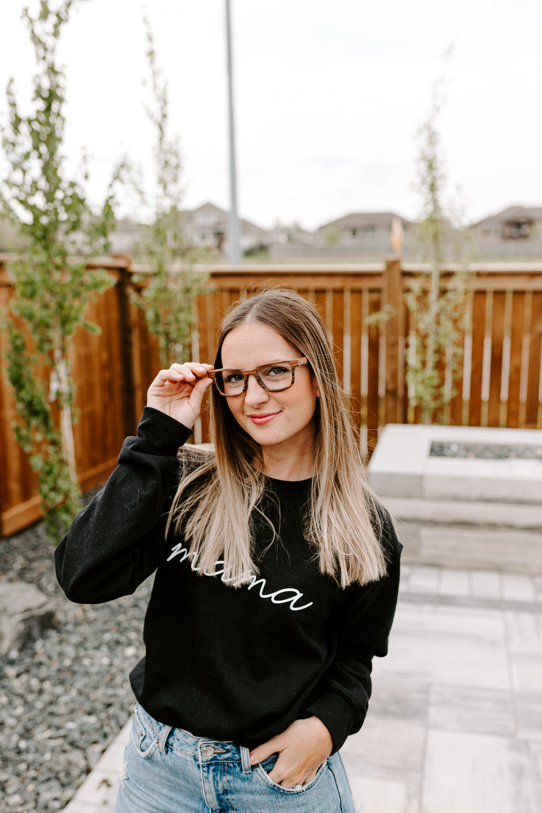 woman with long hair wearing rosewood rectangular optical frames.