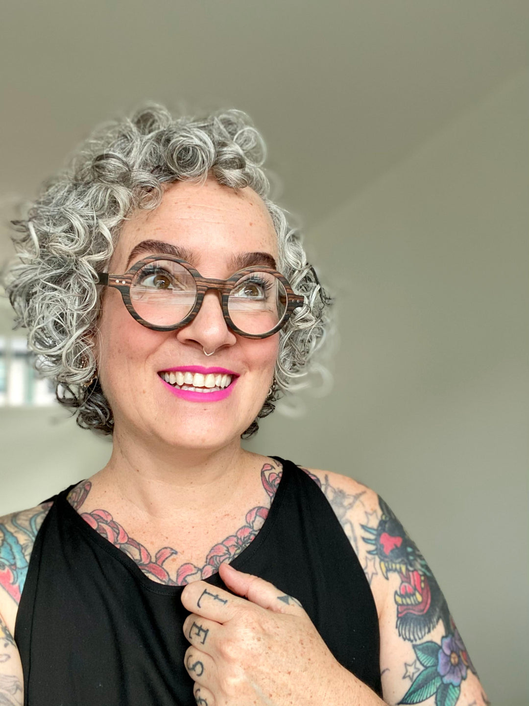 woman with curly hair wearing vintage round glasses.